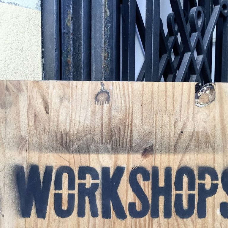 Other services offered Wooden sign with the word "WORKSHOPS" painted in bold black letters.